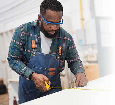 Man working on installations with a measuring tape
