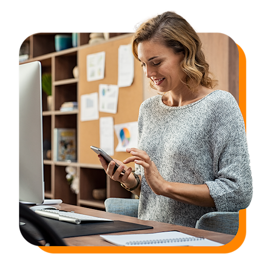 Young woman in an office smiling down at her phone